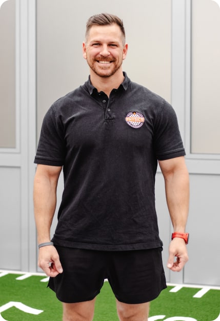 Physiotherapeut Torsten Karbstein steht lächelnd in einem Trainingsraum