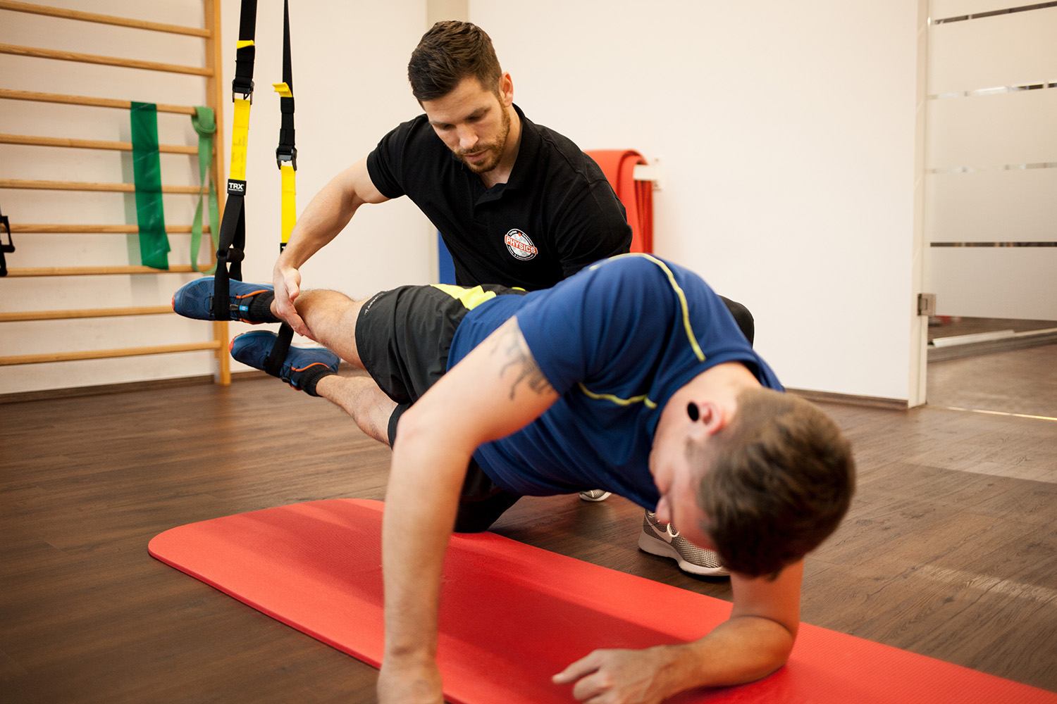 Ein Physiotherapeut gibt Patienten eine Hilfestellung in der Planke